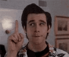 a man is pointing up with his finger and making a face .
