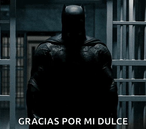 a batman standing in a dark room with gracias por mi dulce written on the bottom