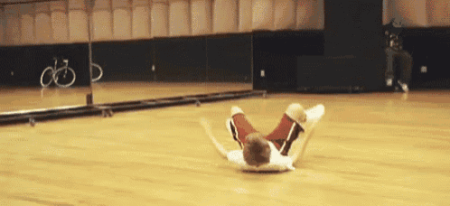 a person is laying on their stomach on the floor in a gym .