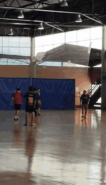 a group of kids are playing basketball in a gym and one of them has the number 10 on their back