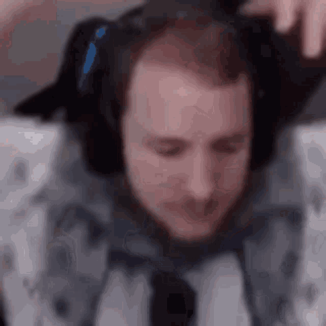 a man wearing headphones is making a funny face while playing a video game .