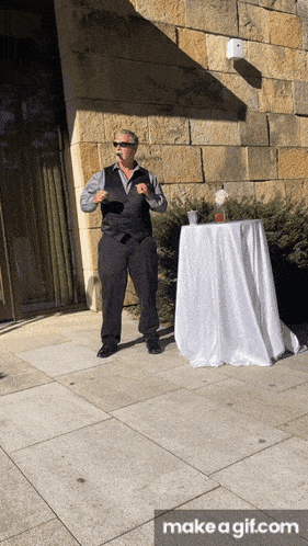 a man in a suit stands in front of a table with a white tablecloth