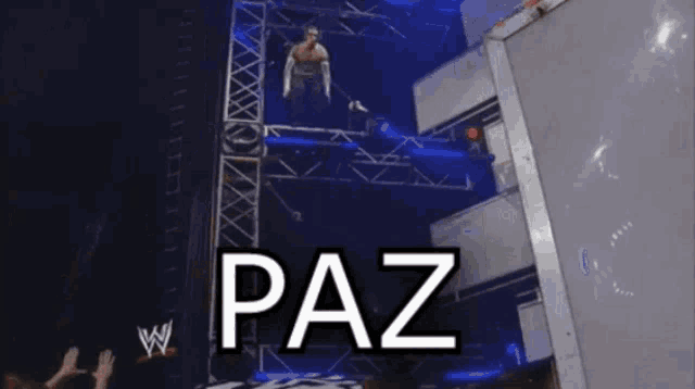 a wrestling match is going on and the words paz are on the screen