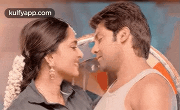 a man and a woman are looking at each other and kissing .