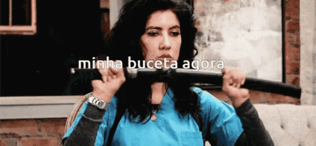 a woman in a blue shirt is holding a barbell with the words minha buceta agora written on the bottom