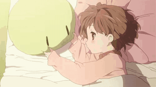 a girl is laying on a bed with a pillow in her hand .