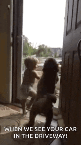 a baby and a dog are standing in front of an open door .