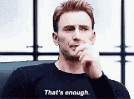 a man wearing a black sweater is sitting in a chair and saying `` that 's enough '' .
