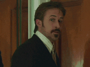 a man in a suit and tie stands in front of a wooden door