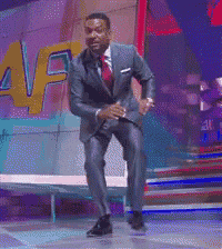 a man in a suit and tie is dancing on a stage in front of a sign that says af