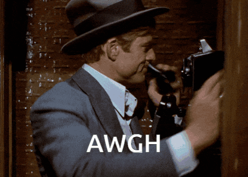 a man in a suit and hat is talking on a pay phone and the word awgh is on the bottom right