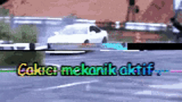 a white car is driving down a road with the words ' cakici mekanik aktif ' on the bottom right