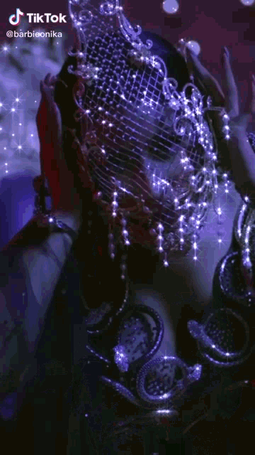 a woman wearing a veil with rhinestones and a snake around her neck .