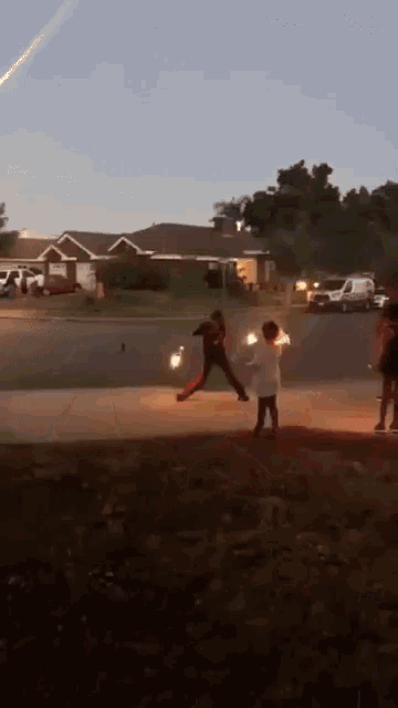 a group of people are playing with sparklers on a street