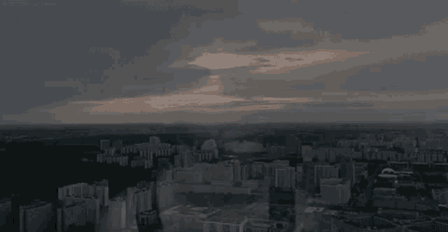 an aerial view of a city at sunset with a cloudy sky .