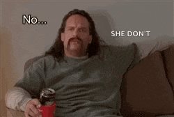 a man with a mustache is sitting on a couch holding a can of soda and a cup .