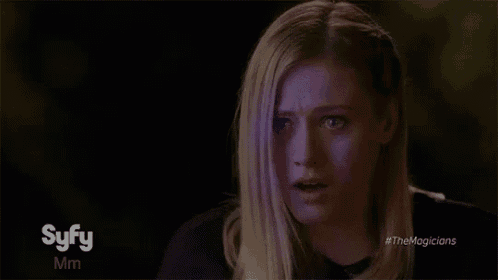 a woman is making a funny face in a dark room .