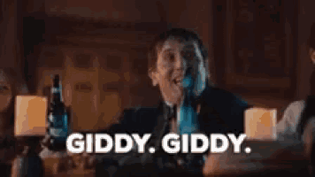 a group of people are toasting with bottles of beer and the words giddy giddy