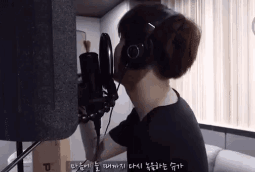 a man wearing headphones is singing into a microphone ..