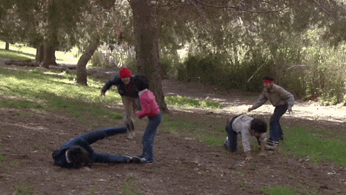 a group of people are playing in a park and one of them is laying on the ground