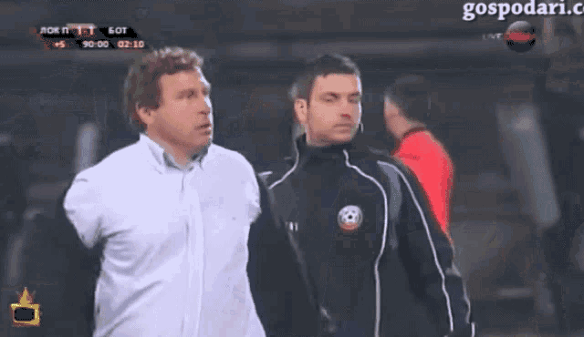 two men standing next to each other with a soccer ball on their jacket