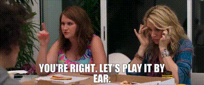 two women are sitting at a table with pizza and a caption that says you 're right let 's play it by ear