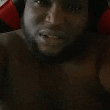 a shirtless man with a beard is taking a selfie with his cell phone .
