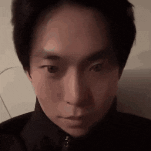 a close up of a young man 's face with a serious look on his face .