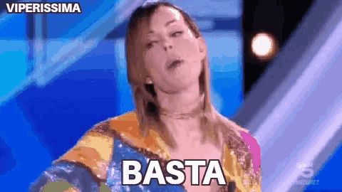 a woman in a colorful dress is standing on a stage and says basta
