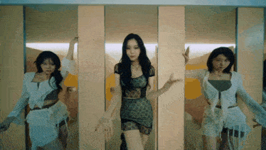 three women are dancing in front of a mirror in a bathroom