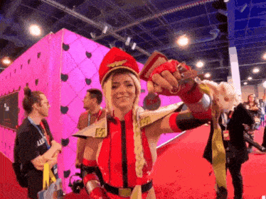 a woman in a red and gold costume holds a sword in her hand