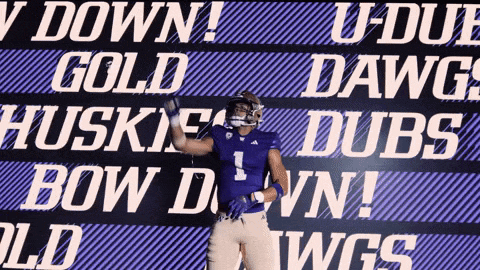 a football player stands in front of a sign that says u-duf