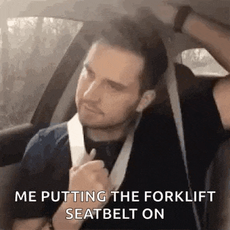 a man is sitting in a car wearing a seat belt and a forklift seat belt .