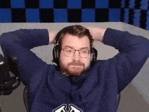 a man with a beard and glasses is wearing headphones .