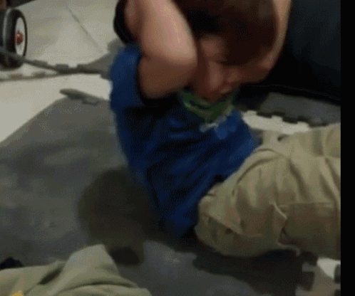 a man in a blue shirt is doing crunches on the floor