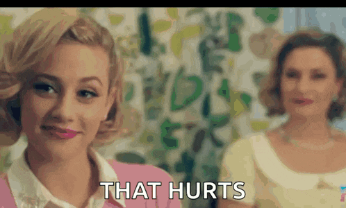 a woman in a pink shirt is standing next to another woman in a yellow shirt and says that hurts .