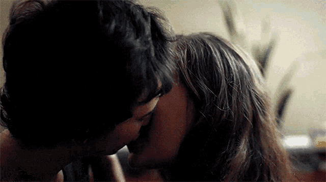 a close up of a man and woman kissing