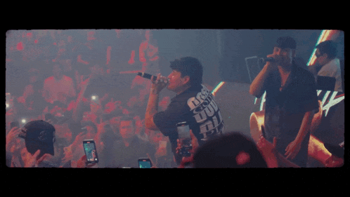 a man singing into a microphone while wearing a shirt that says dsg on it