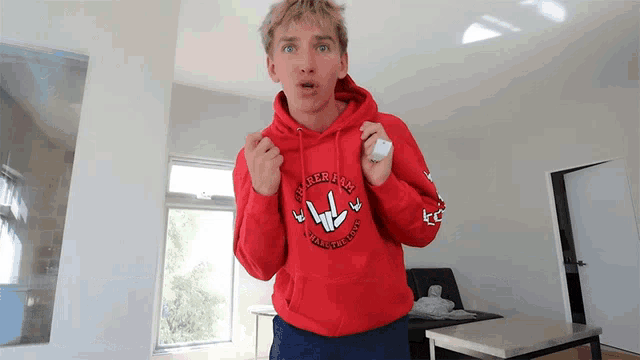 a young man wearing a red hoodie that says ' i love you ' on it