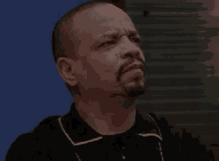 a man with a beard and a black shirt is making a face