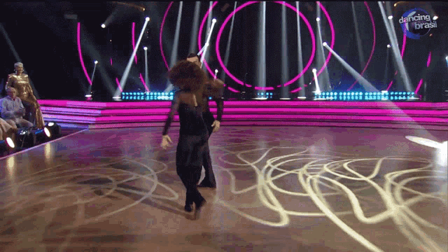 a man and woman are dancing on a stage with dancing brasil written on the bottom