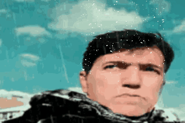 a man is standing in the rain with snow falling on him