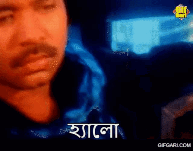 a man with a mustache is making a funny face in front of a computer screen with a blue background .