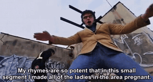 a man is standing in front of a building with graffiti on it and says my rhymes