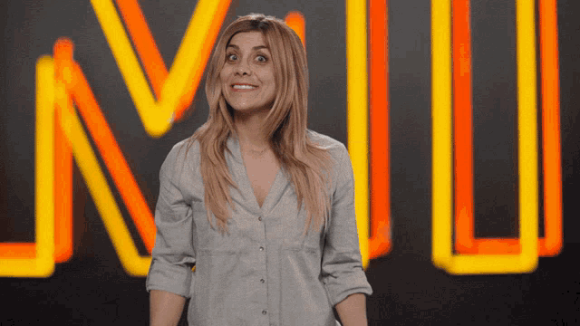 a woman stands in front of a neon sign that says n