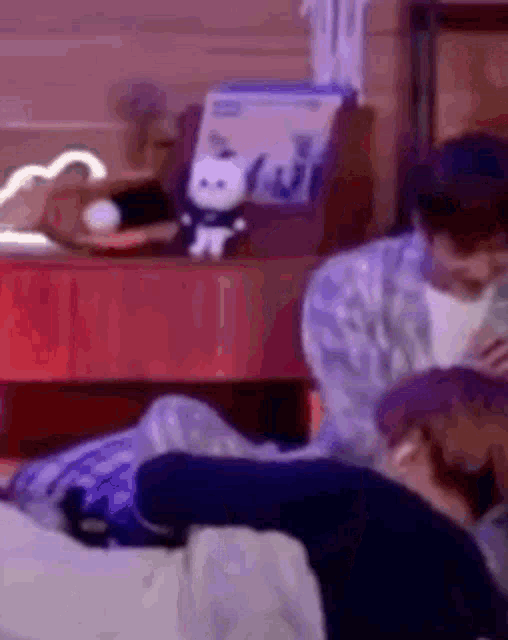 a man is laying on a bed next to another man who is laying on a bed .