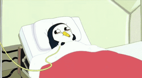 a penguin is laying in a hospital bed with a hose attached to its nose