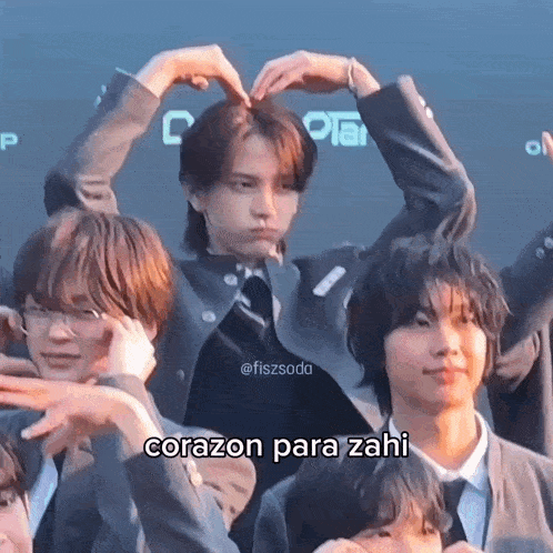 a group of young men are making a heart with their hands .