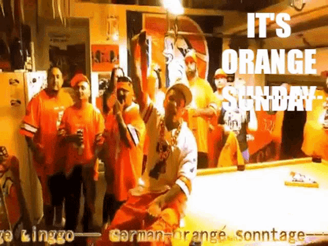 a group of people standing around a pool table with the words it 's orange sunday written on the bottom