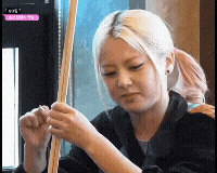 a woman with blonde hair is holding a stick in her hand .